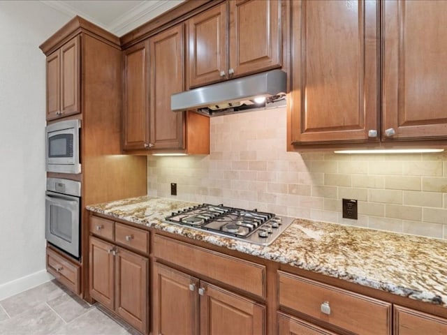 kitchen with light stone countertops, crown molding, stainless steel appliances, and tasteful backsplash