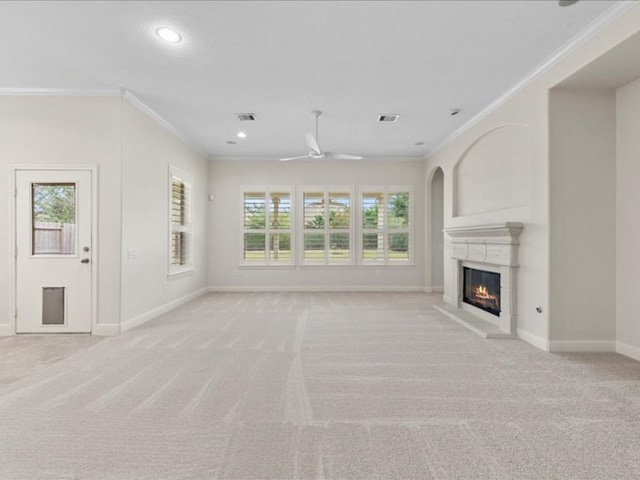 unfurnished living room featuring light carpet, crown molding, and a healthy amount of sunlight