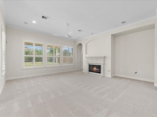 unfurnished living room with crown molding, light colored carpet, and ceiling fan