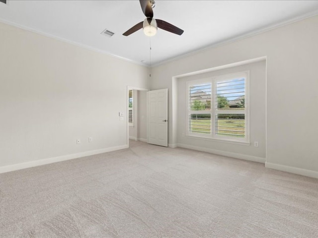 empty room featuring ornamental molding, light carpet, and ceiling fan