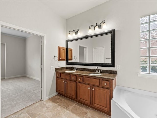 9410 Trinity Trail Ct, Cypress, TX 77433 - bathroom with double vanity, a garden tub, and baseboards