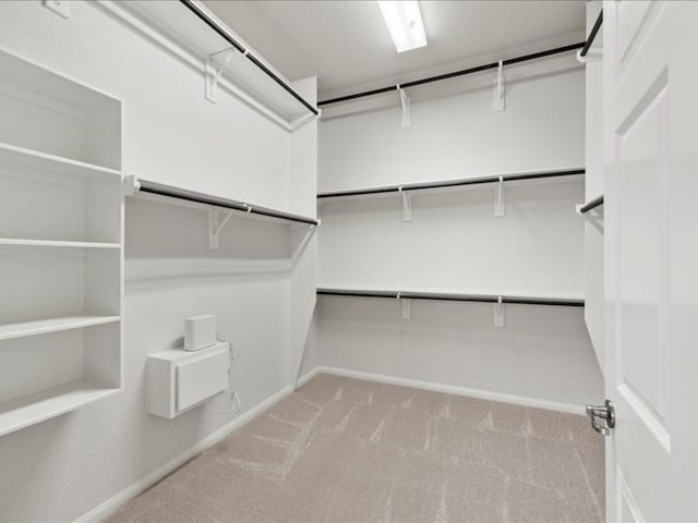 walk in closet featuring light carpet