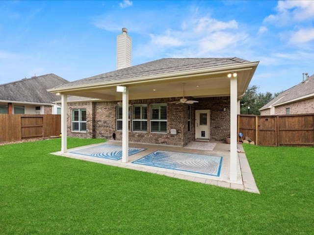 rear view of house with a patio area, a lawn, and ceiling fan