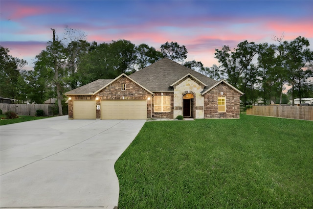 view of front of property with a garage and a yard