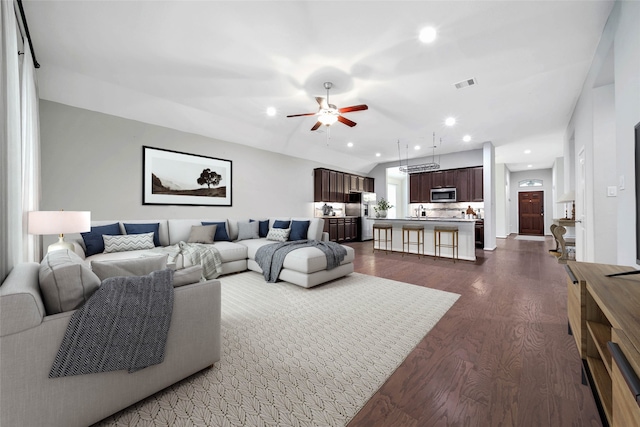 living room featuring dark hardwood / wood-style flooring and ceiling fan