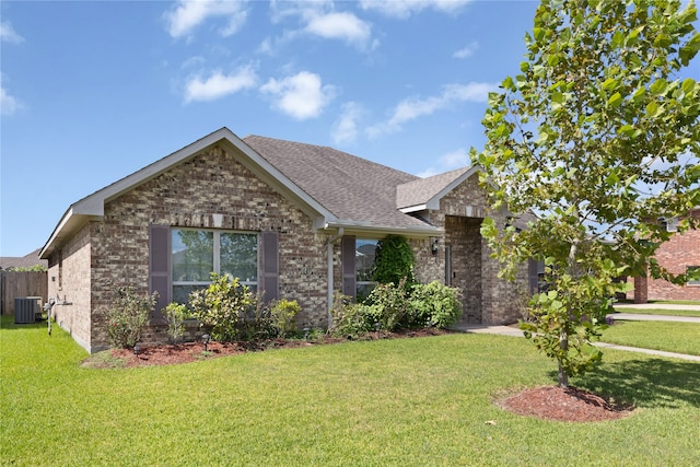 view of front of house with a front yard and central AC