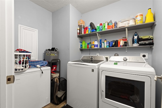 clothes washing area with a textured ceiling and washing machine and clothes dryer