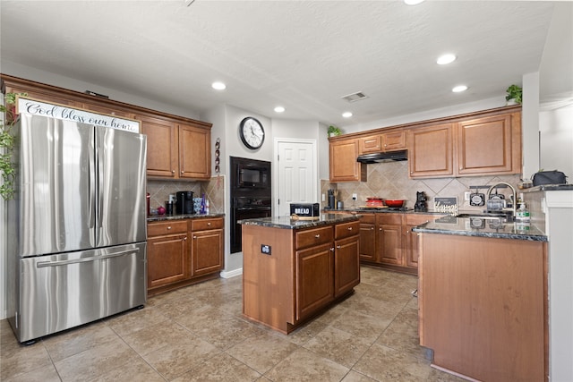 kitchen featuring black appliances, a kitchen island, a textured ceiling, dark stone counters, and decorative backsplash