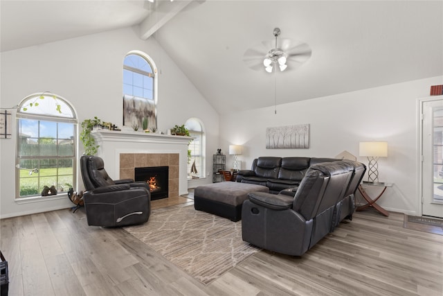 living room featuring ceiling fan, wood-type flooring, a fireplace, and a wealth of natural light