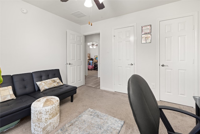 carpeted office space featuring ceiling fan