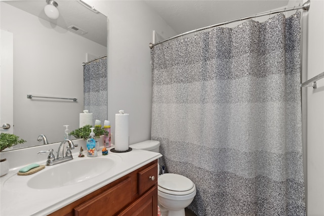 bathroom with vanity, toilet, and curtained shower