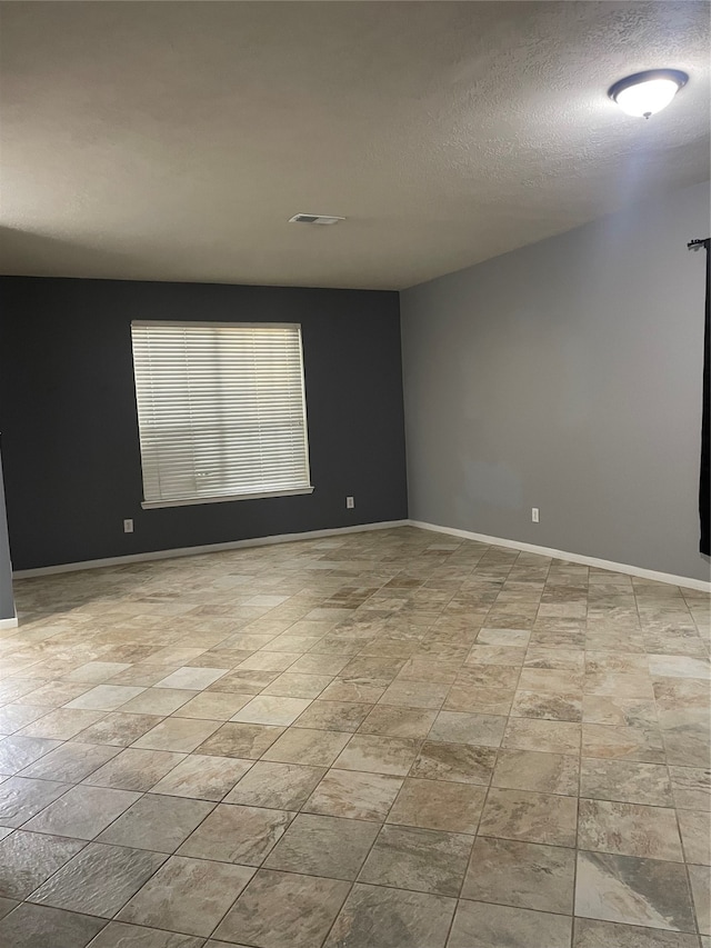 unfurnished room featuring a textured ceiling