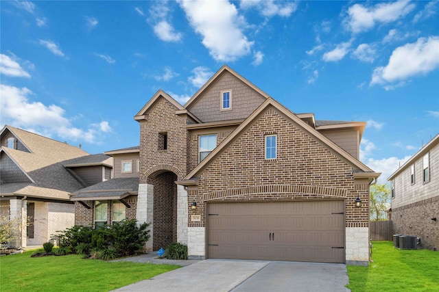 view of front of property featuring a garage, a front yard, and central AC