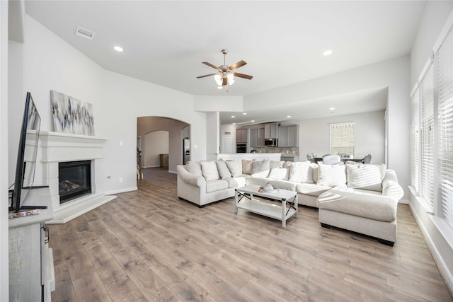 living room with ceiling fan and light hardwood / wood-style flooring