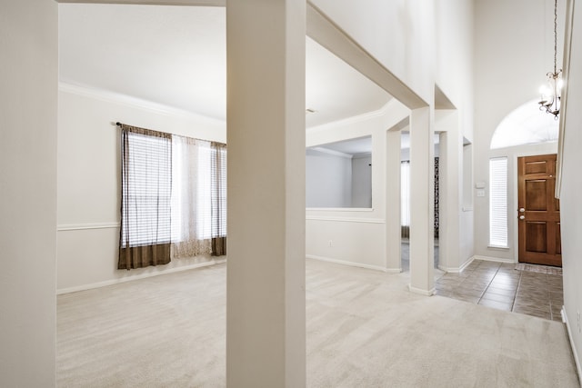 foyer featuring ornamental molding, light colored carpet, and a towering ceiling