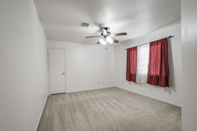 empty room with light carpet, a textured ceiling, and ceiling fan