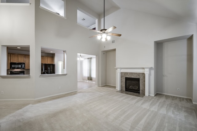 unfurnished living room with light carpet, high vaulted ceiling, a fireplace, and ceiling fan