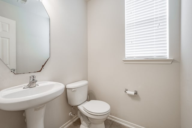 bathroom with toilet and tile patterned flooring