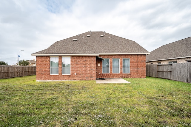 rear view of house with a patio area and a lawn