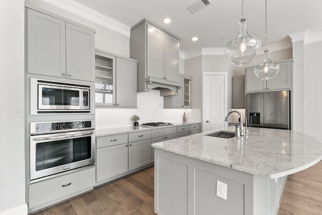 kitchen with dark hardwood / wood-style flooring, stainless steel appliances, sink, a center island with sink, and gray cabinets