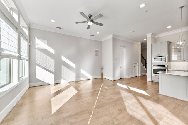 unfurnished living room with crown molding and light hardwood / wood-style floors