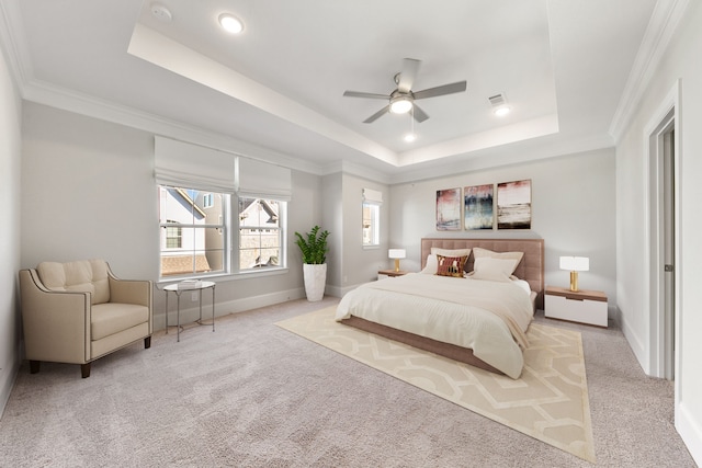 bedroom with ceiling fan, ornamental molding, light carpet, and a tray ceiling