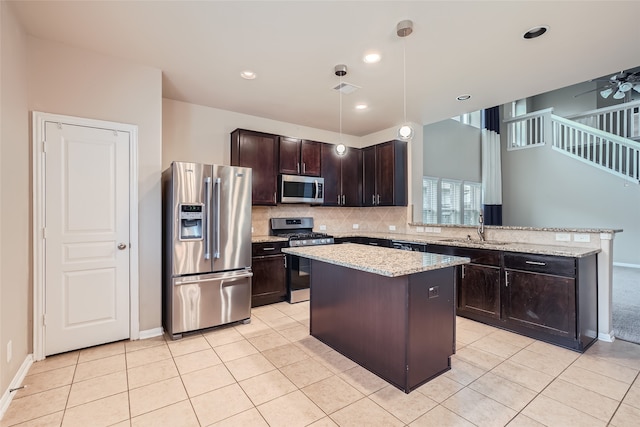 kitchen with stainless steel appliances, sink, a center island, dark brown cabinetry, and decorative light fixtures