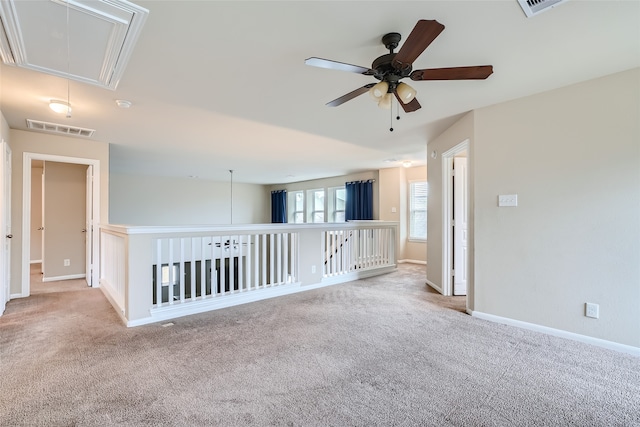 spare room featuring light colored carpet and ceiling fan