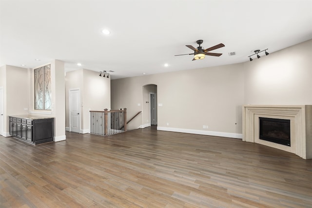 unfurnished living room featuring wood-type flooring and ceiling fan