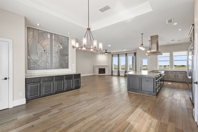 kitchen with a kitchen island, island exhaust hood, dark hardwood / wood-style floors, and plenty of natural light