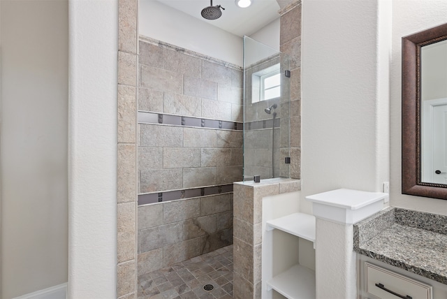 bathroom with vanity and tiled shower