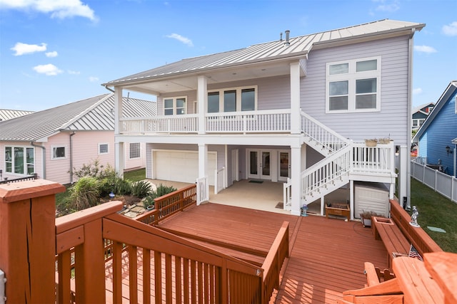 rear view of property with a garage and a deck