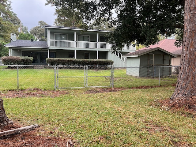 rear view of house with a storage shed, a yard, and a balcony