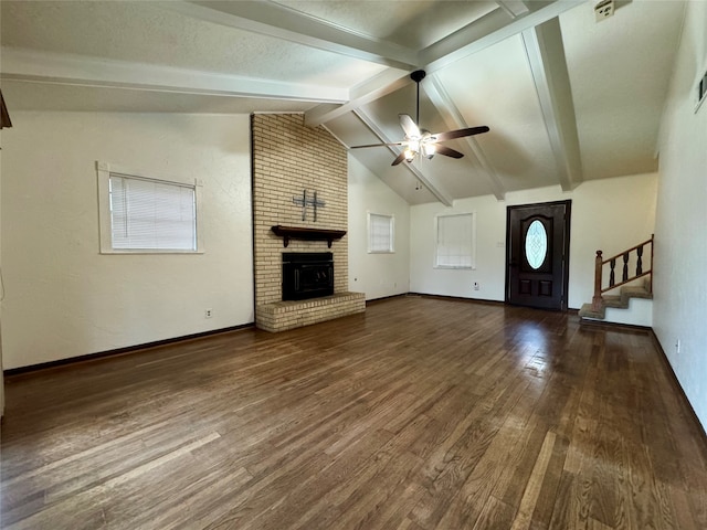 unfurnished living room featuring ceiling fan, a fireplace, vaulted ceiling with beams, and dark hardwood / wood-style floors