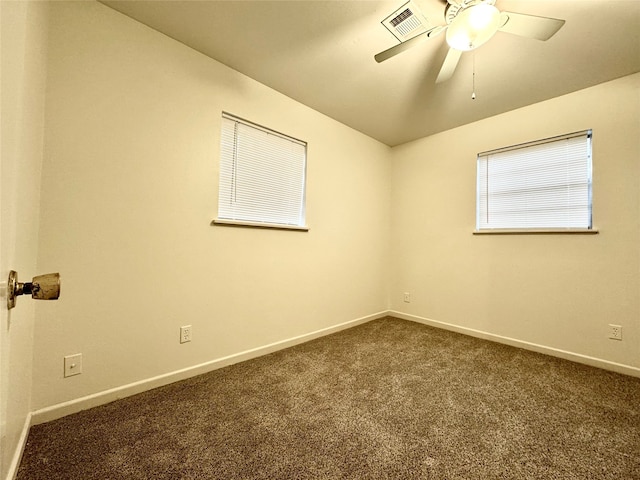 empty room with ceiling fan and dark carpet