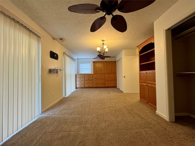 hallway featuring a textured ceiling, a chandelier, and light colored carpet