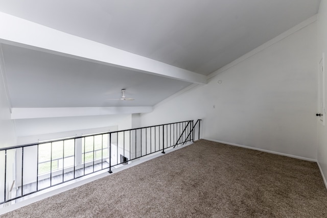 carpeted empty room with lofted ceiling with beams and ceiling fan