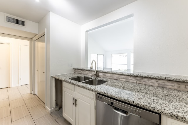 kitchen featuring light stone countertops, sink, white cabinetry, vaulted ceiling, and stainless steel dishwasher