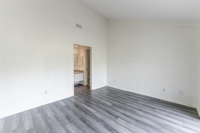 spare room with high vaulted ceiling and light hardwood / wood-style flooring