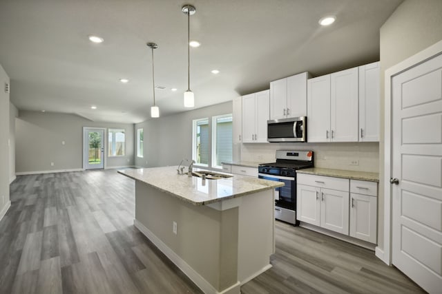 kitchen with white cabinets, hanging light fixtures, appliances with stainless steel finishes, and tasteful backsplash