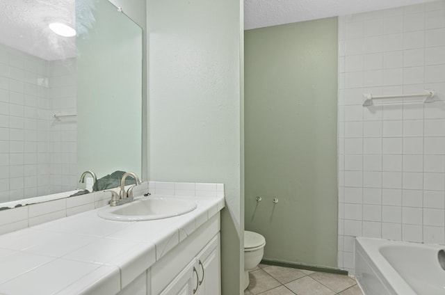 bathroom featuring tile patterned flooring, vanity, toilet, and a textured ceiling