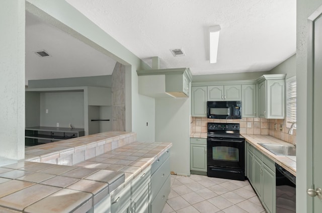 kitchen with sink, tasteful backsplash, tile countertops, light tile patterned floors, and black appliances