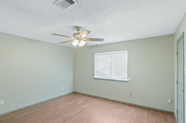 unfurnished room featuring a textured ceiling and light hardwood / wood-style flooring