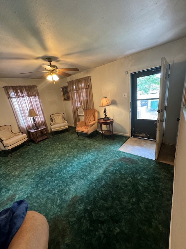 living area featuring carpet and ceiling fan