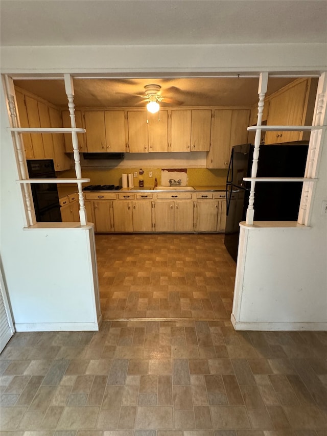 kitchen featuring light brown cabinets and black fridge