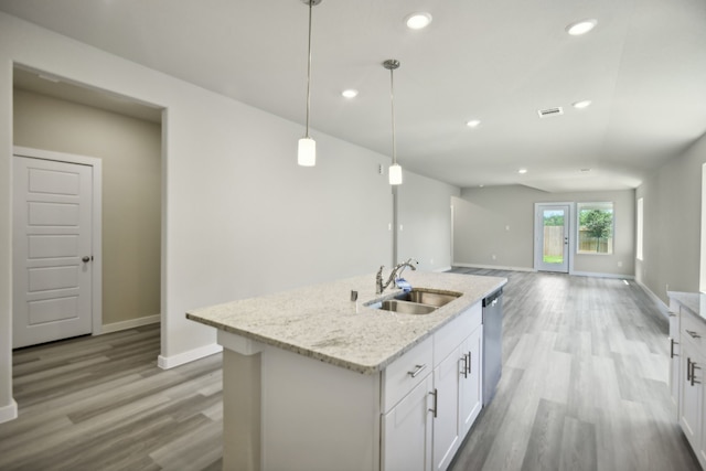 kitchen featuring sink, white cabinetry, light stone counters, decorative light fixtures, and stainless steel dishwasher