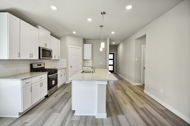 kitchen featuring pendant lighting, white cabinetry, and appliances with stainless steel finishes