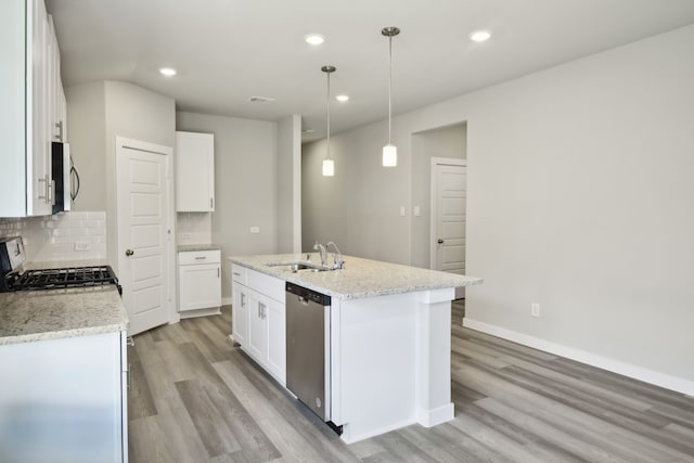 kitchen with sink, appliances with stainless steel finishes, white cabinetry, a kitchen island with sink, and decorative light fixtures