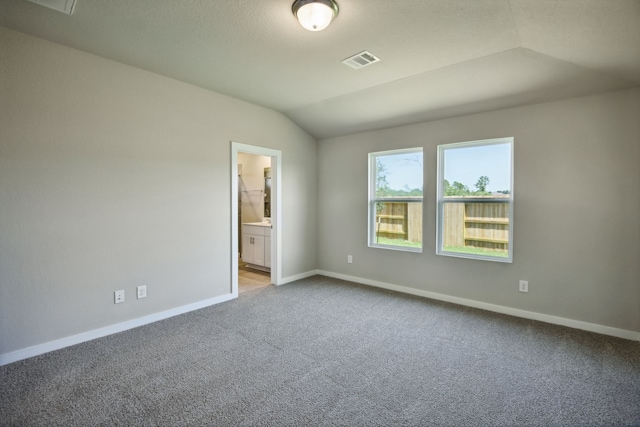 carpeted spare room featuring lofted ceiling