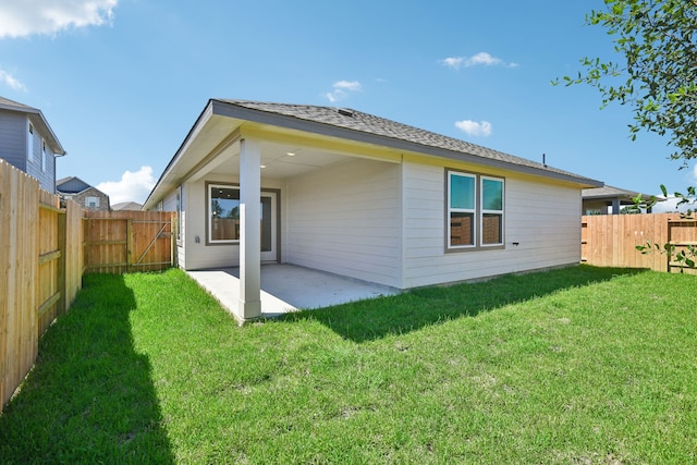 back of property with a lawn and a patio area